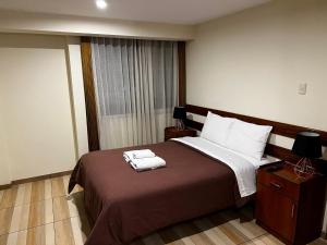 Una habitación de hotel con una cama con toallas. en Stay in AQP Apartments, en Arequipa