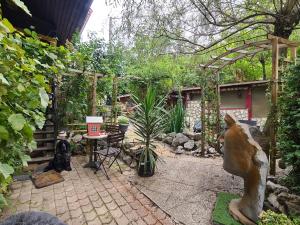 un giardino con patio e statua di un cane di Chez steph et frank a Morez