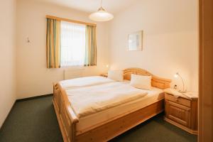 a bedroom with a wooden bed and a window at Appartementhaus Samson Fanningberg in Weisspriach