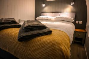 um quarto com uma cama com toalhas em Newmore Highland Pods with Hot Tubs on NC500 em Invergordon