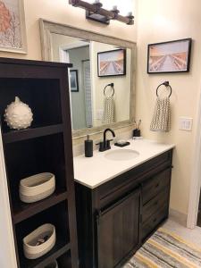 La salle de bains est pourvue d'un lavabo et d'un miroir. dans l'établissement 3 BDRM cottage w/hot tub, near fishing, beach & DT, à Jensen Beach