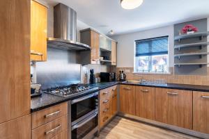 a kitchen with wooden cabinets and a stove top oven at Contractor*Leisure*King Bed*Free Parking in Hull