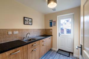 uma cozinha com um lavatório, uma janela e uma porta em Contractor*Leisure*King Bed*Free Parking em Hull