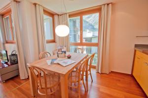 eine Küche und ein Esszimmer mit einem Holztisch und Stühlen in der Unterkunft Casa D'Amore, Apartment Lyskamm in Zermatt