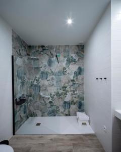 a bathroom with a stone wall at Apartamentos Rosa Velázquez in Mérida +78 photos