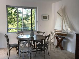 un comedor con mesa y sillas y un velero en Vue Superbe sur Tour de la Lanterne T2 avec Terrasse Remparts 2, en La Rochelle 12 fotos más