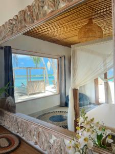 a mirror in a room with a view of the ocean at Met House in Thulusdhoo