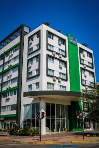 un edificio blanco y verde en una calle de la ciudad en Ecohotel Talca en Talca