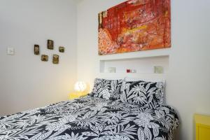 un dormitorio con una cama en blanco y negro y una pintura en BestHostRio - Leblon 2 Quartos 500 metros da praia, en Río de Janeiro