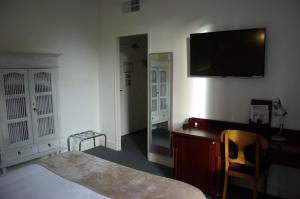 Pokój z łóżkiem, biurkiem i telewizorem w obiekcie The Originals Boutique, Villa Montpensier, Pau (Inter-Hotel) w mieście Pau