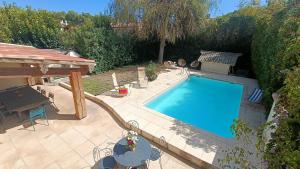 - une piscine dans un jardin avec une table et des chaises dans l'établissement Grande maison familiale avec piscine, proche plage, à Villeneuve-lès-Béziers