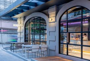 a restaurant with tables and chairs in a building at The Period Pratunam in Bangkok