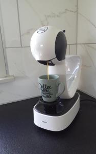 een koffiezetapparaat met een kopje op een aanrecht bij Villa 't Zonneroosje in Nieuwpoort