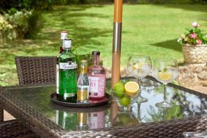 uma mesa com garrafas de álcool e copos em Easington Guest House em Banbury