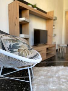 un soggiorno con sedia bianca e TV di Cà Adri , appartamento in posizione strategica per godere delle spiaggia e dei sentieri Outdoor ! a Finale Ligure
