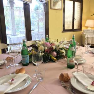 un tavolo con bottiglie di vino, piatti e bicchieri di Hotel Ristorante Gallo D'Oro a Vignola