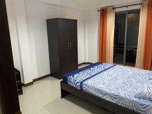 Sunrise Kadawatha Apartments في Kadawata: غرفة نوم بسرير وخزانة ونافذة