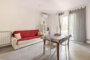 een woonkamer met een rode bank en een tafel bij 2locale Cervo in Cervo