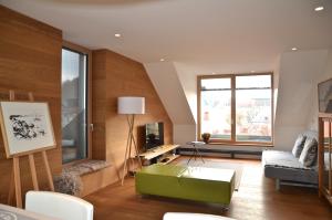 a living room with a green ottoman and a couch at i Design Apartment in Ljubljana