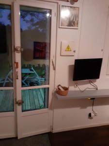 une porte avec une télévision dans une pièce dans l'établissement jolie cocon au coeur de la nature, à Durtal