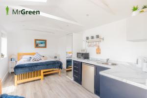 1 dormitorio con 1 cama y cocina con fregadero en Wick Studio en Christchurch