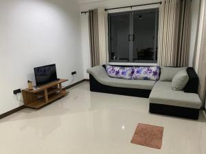 Sunrise Kadawatha Apartments في Kadawata: غرفة معيشة مع أريكة وطاولة قهوة