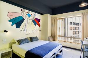1 dormitorio con 1 cama con una pintura en la pared en Abraham Tel Aviv en Tel Aviv