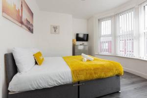 a bedroom with a bed with a yellow blanket on it at Modern Family Home With Parking-Pem in Liverpool