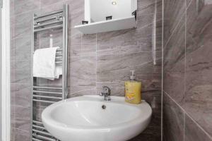 a bathroom with a white sink and a mirror at Modern Family Home With Parking-Pem in Liverpool