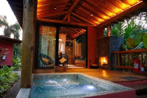 a house with a swimming pool and a fireplace at Villa Manakás in Camburi