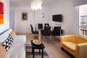 a living room with a couch and a table with chairs at Garcia Briz by Bossh! Apartments in Málaga