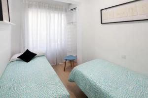 a bedroom with two twin beds and a table at Garcia Briz by Bossh! Apartments in Málaga