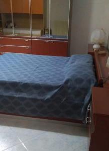 una camera da letto con un letto con una coperta blu sopra di Il casale dell'artista a Laino Borgo