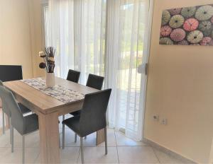 una mesa de comedor con sillas y un jarrón de flores en Villa Anna, en Skala Rachoniou