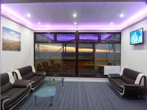 a living room with two couches and a large window at Funky Towers in Blackpool