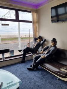 two men in hats sitting on a couch in a room at Funky Towers in Blackpool