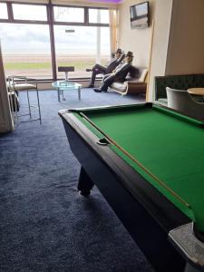 a pool table in a room with two people sitting at Funky Towers in Blackpool