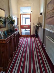 a hallway with a red and white striped carpet at Funky Towers in Blackpool