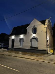 Un bâtiment blanc avec des lumières sur le côté d'une rue dans l'établissement Côté Village By Mel & Jérôme, 