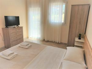 1 dormitorio con cama y vestidor con TV en Villa Anna, en Skala Rachoniou