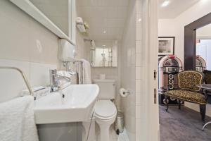 a white bathroom with a sink and a toilet at Finest Retreats - Hanover Mews in London