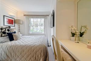 a bedroom with a bed and a desk and a window at Finest Retreats - Hanover Mews in London
