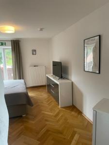 Schlafzimmer mit einem Bett und einem Schreibtisch mit einem TV in der Unterkunft WuhrsteinHaus in Schleching