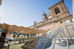 a large building with a clock on top of it at Oasis Backpackers' Hostel Sevilla & Coworking in Seville