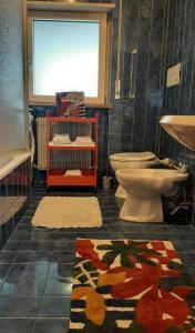 uma casa de banho com um WC, um lavatório e um tapete em LAnJA ihr besonderes Urlaubszuhause em Lagundo