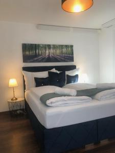 een slaapkamer met een groot bed met kussens bij Grubenmann Appartements - Sankt Gallen City in St. Gallen
