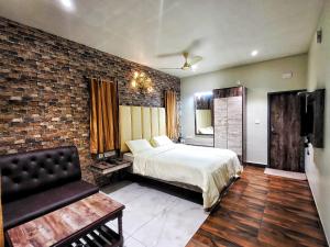 a bedroom with a bed and a brick wall at MM Resorts in Yercaud