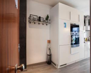 uma cozinha com armários brancos e um frigorífico em Stay Unique Apartments Aprestadora em L'Hospitalet de Llobregat