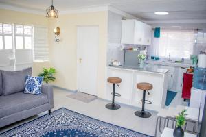 a living room with a couch and a kitchen at Arabella Suites - Karen in Karen