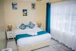 sypialnia z łóżkiem z ręcznikami w obiekcie Arabella Suites - Karen w mieście Karen